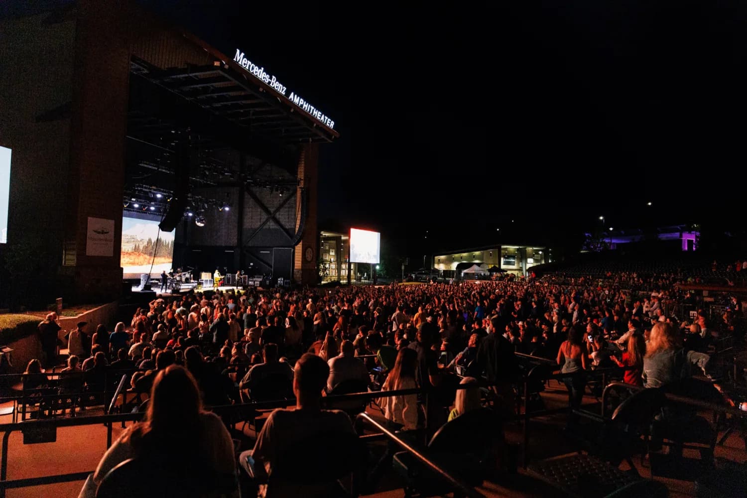 A packed crowd at the Mercedes-Benz Amphitheater on a summer night in Tuscaloosa